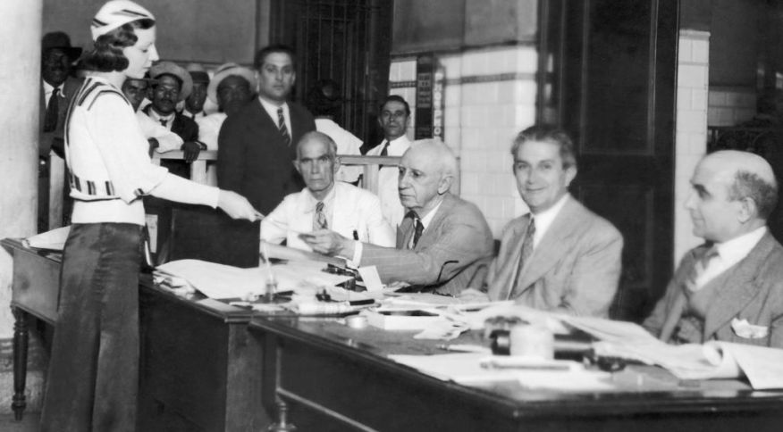 Eleitora mostra o cartão de voto na eleição de 1934, a primeira em que mulheres tiveram o direito de votar no Brasil